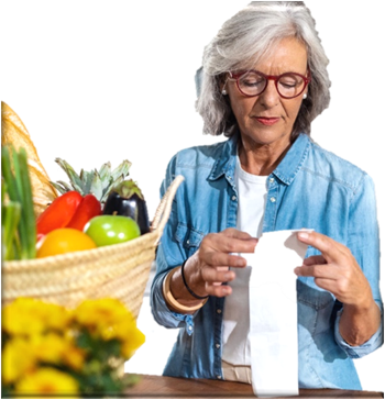 Woman looking at her grocery receipt with a basket of fruit next to her. 