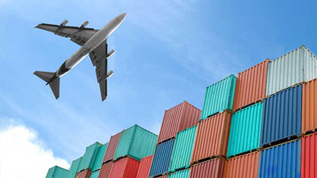 Charter airplane in sky over shipping containers