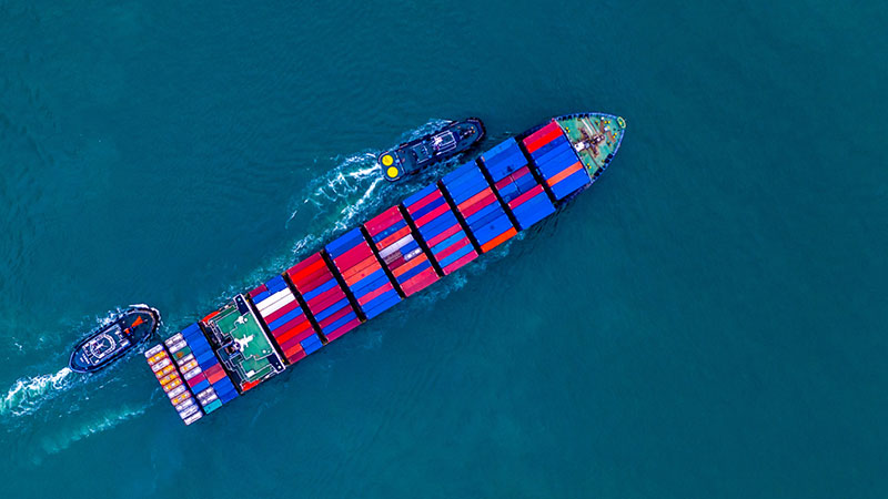 container ship being guided into port